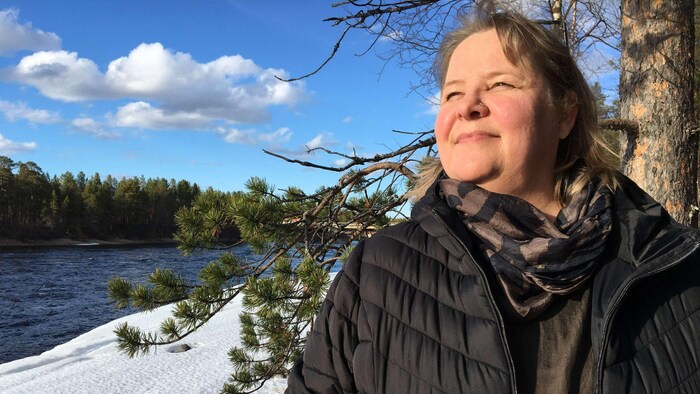 Kirsi Suomi pose en hiver près d'une rivière.