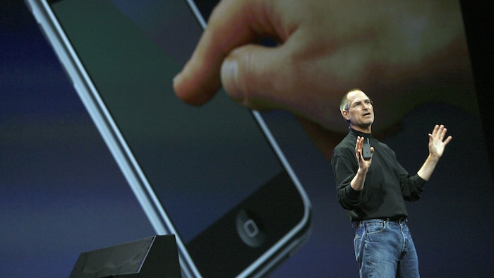 Steve Jobs devant un immense écran, lors d’une présentation de l’iPhone.