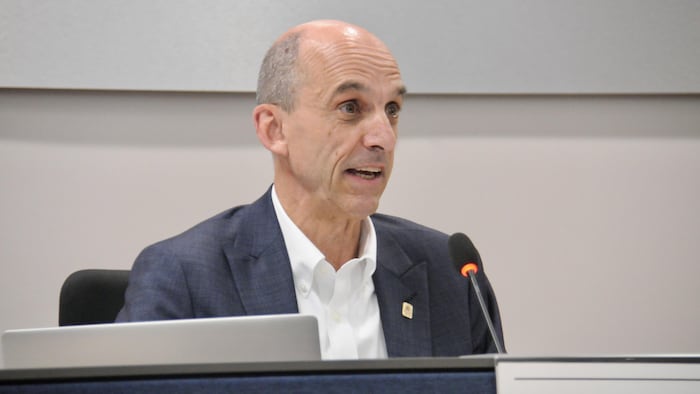 Steven Blaney derrière un micro lors d'une séance ordinaire du conseil municipal de Lévis.