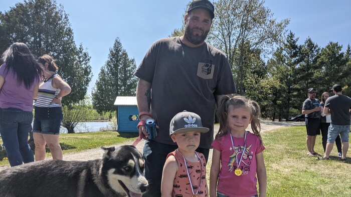 un homme et deux enfants avec un chien