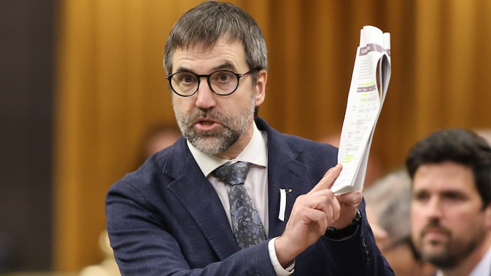 Steven Guilbeault tient des documents qu'il pointe en prenant la parole dans la Chambre des communes.