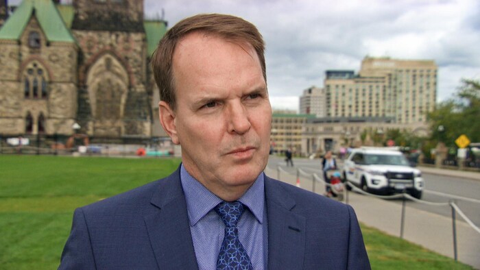 Steven MacKinnon en entrevue sur la colline du Parlement à l'extérieur devant la pelouse.