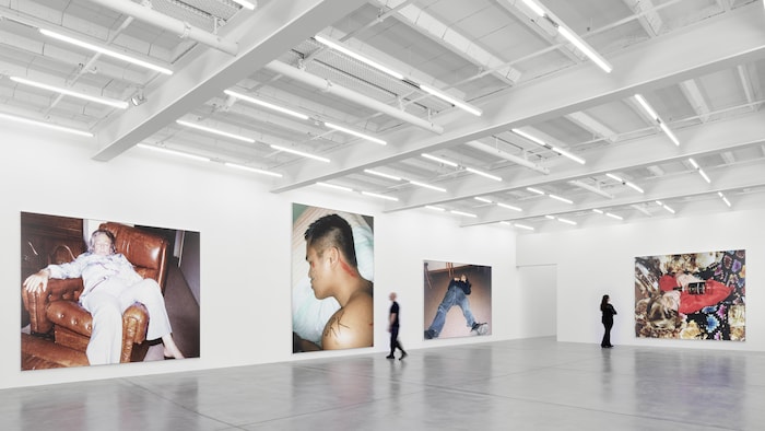 Salle d'exposition avec de grandes photos sur les murs.