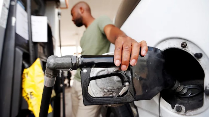 Un hombre carga combustible en su vehículo.