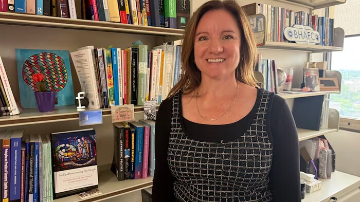 Amanda Friensen pose devant une bibliothèque pleine de livres.