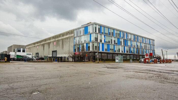Un grand bâtiment en béton vu de l'autre côté d'une rue.