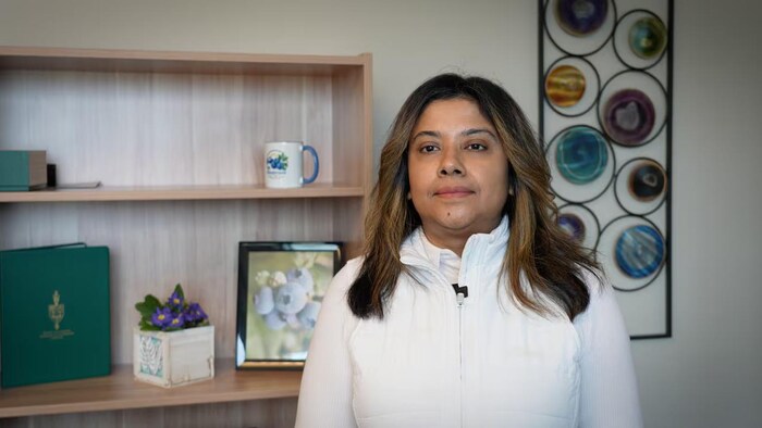 Sudeshna Nambiar, derrière elle, une photo de bleuets.