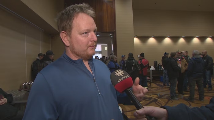 Jason Sullivan interviewé dans une salle de conférence.