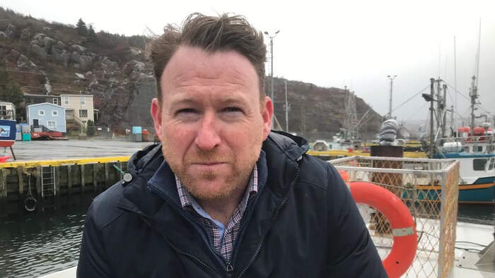 Keith Sullivan est interviewé sur un quai.