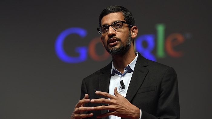 Le PDG de Google et Alphabet Sundar Pichai parle sur une scène devant le logo de Google. 