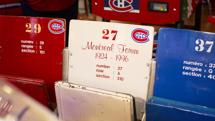 Trois sièges de l'ancien Forum de Montréal sont placés en rangée.