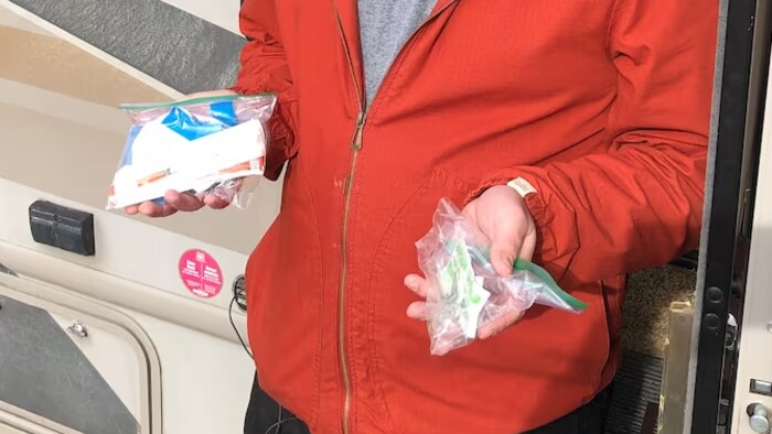 Une personne tient deux sacs de drogue.
