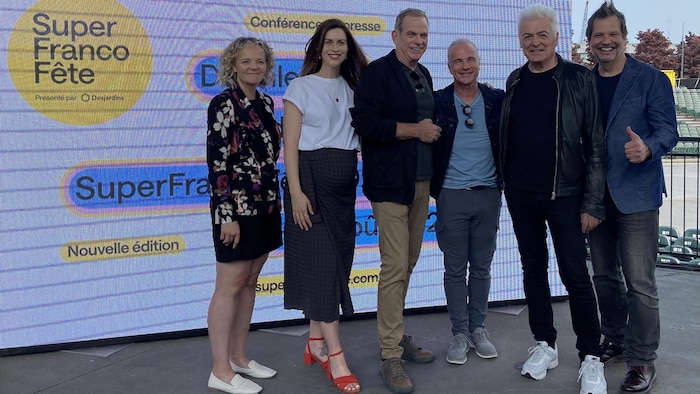 Deux femmes et quatre hommes prennent la pose sur une scène.