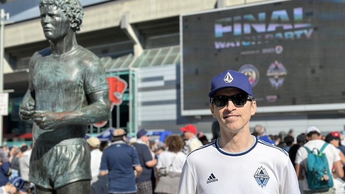 Craig Flamma à côté de la statue de Terry Fox.