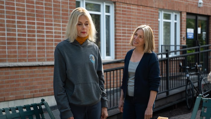 Deux femmes discutent à l'extérieur d'un centre communautaire.