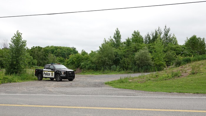 Un camion de la Sûreté du Québec est stationné en bordure d'une route.