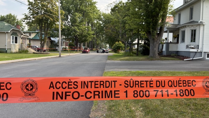 Un véhicule de police est sur les lieux, dans un quartier résidentiel.