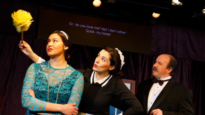 Une pièce de théâtre de la Troupe du Jour, à Saskatoon, au-dessus de laquelle sont projetés des surtitres anglais.