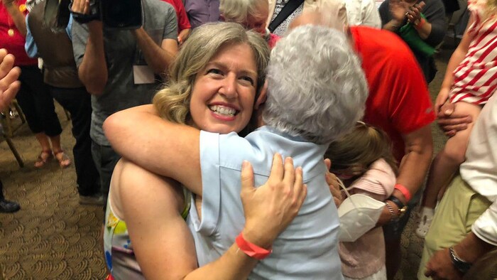 Susan Holt serre dans ses bras une autre femme, plus âgée.