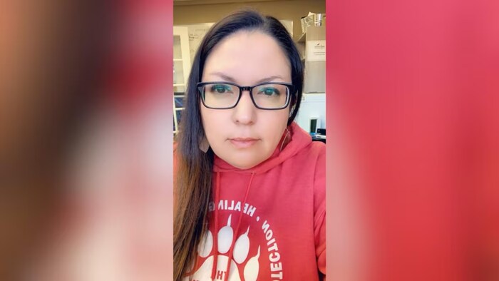 Une femme en tricot rouge et en lunettes.