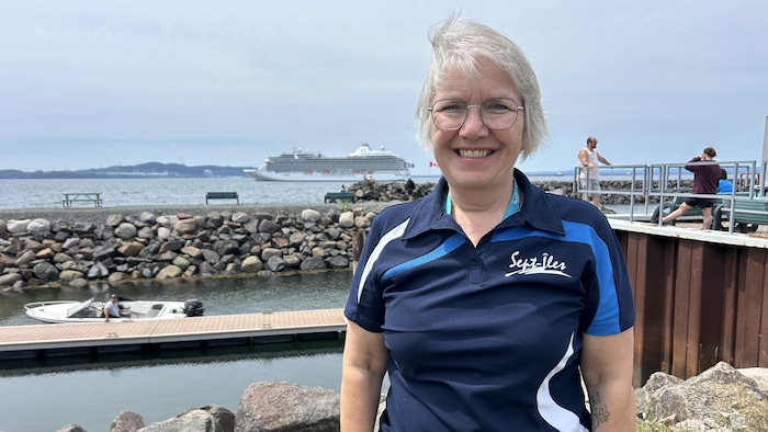 Suzanne Cassista est au port de Sept-Îles devant le bateau de croisière Oceania Marina. 