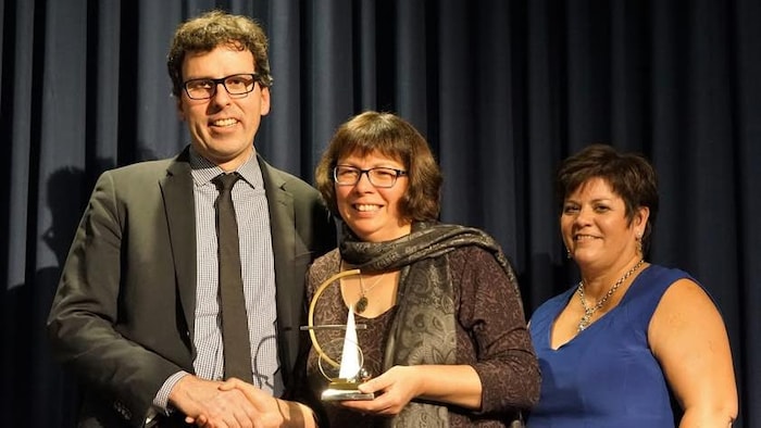 Suzette Montreuil, qui tient un trophée dans ses mains.
