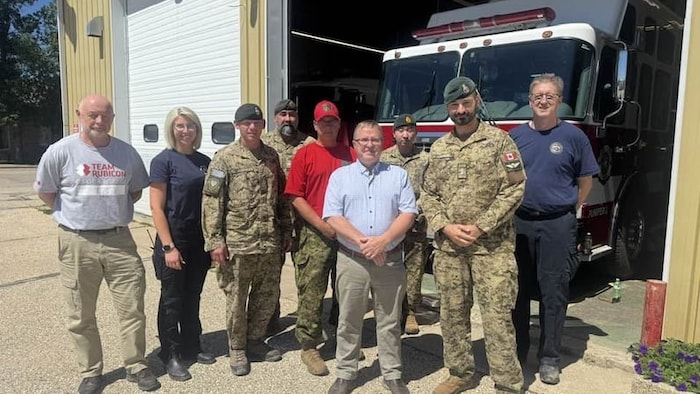 Des membres de l'armée et de Team Rubicon prennent la pose ensemble.