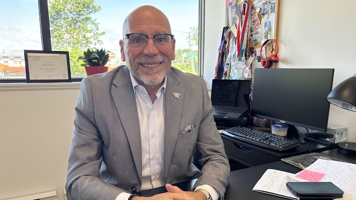 Sylvain Croteau pose pour une photo assis à son bureau.