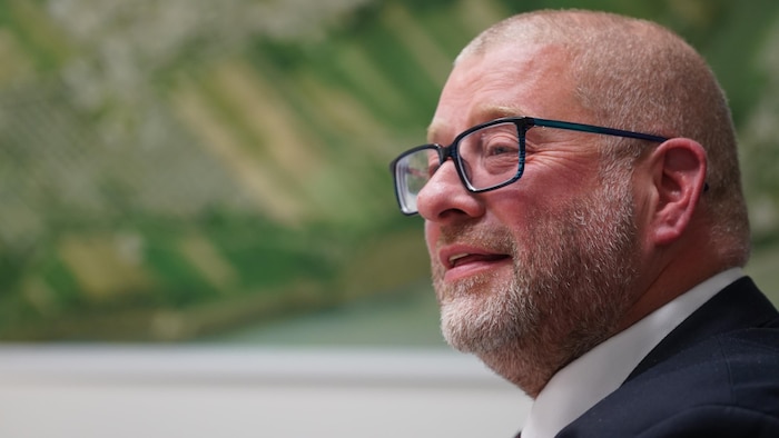 Le maire de Saint-Augustin-de-Desmaures, Sylvain Juneau, devant la carte de sa ville.