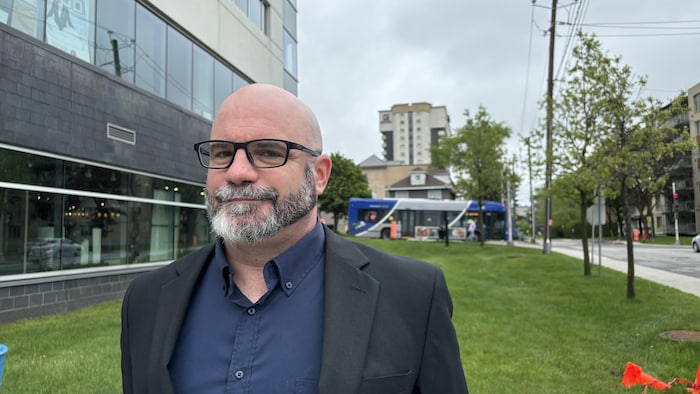 Sylvain Milot devant un édifice, dans la ville de Québec.