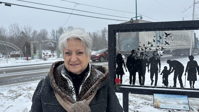Sylvie Blanchette devant un monument commémoratif de l'attaque au camion-bélier d'Amqui. 