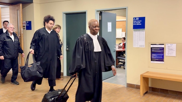 L'avocate sort de la salle d'audience suivie des parents de son client.