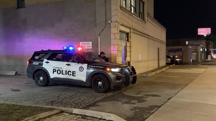 Une voiture de police est stationnée sur une rue latérale derrière la synagogue Chasidei Bobov à North York.