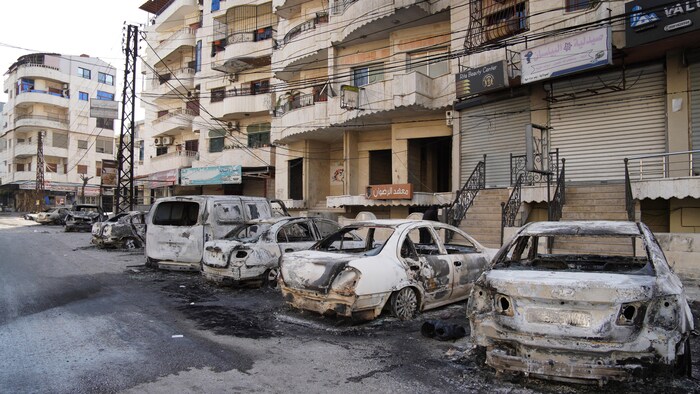 Une rangée de voitures brûlées.