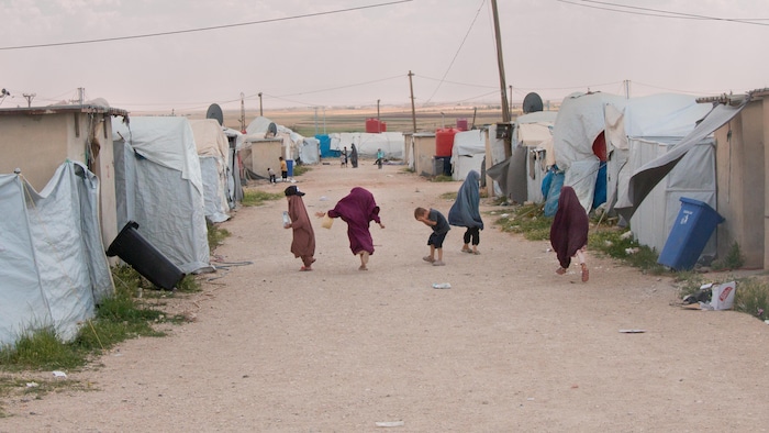 Niños corriendo entre las tiendas de un campamento.