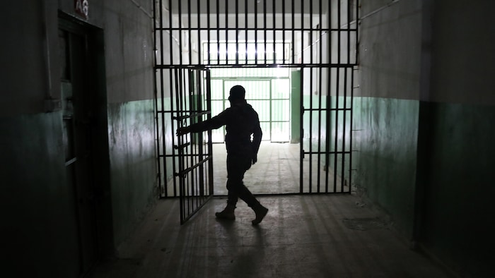 حارس يفتح باب سجن، في 7 كانون الثاني (يناير) 2020، في منطقة الحسكة في شمال شرق سوريا يُحتجز فيه أجانب يُشتبه في قتالهم في صفوف تنظيم ’’الدولة الإسلامية‘‘ المسلّح.
