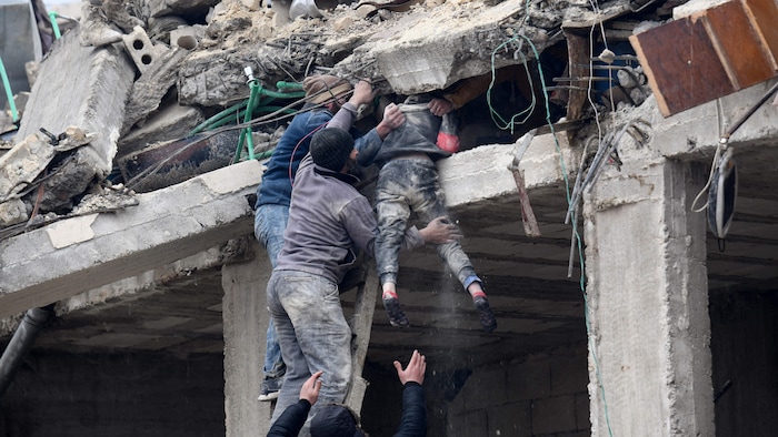 Residents help an injured girl out of rubble in Jandairis, northwestern Syria, February 6, 2023.
