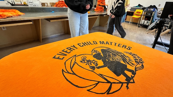 Un t-shirt orange avec une illustration créée par une étudiante.