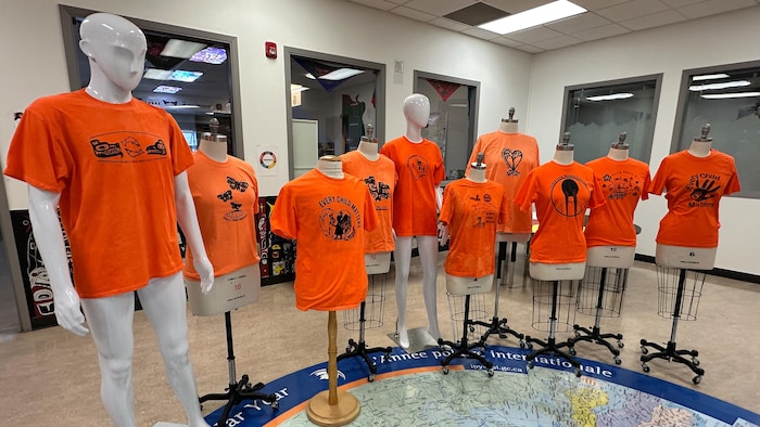Tous les t-shirts orange produits depuis six ans sont présentés sur des mannequins dans le corridor de l'école. 