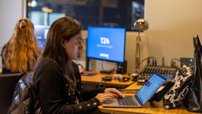 Une femme tape sur un clavier d'ordinateur.
