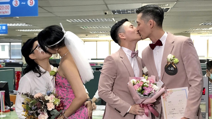 In this Friday, May 24, 2019, file photo, two same-sex couples seal their legal marriage with a kiss at the registration office in Xingyi District in Taipei, Taiwan. Hundreds of same-sex couples in Taiwan are rushing to the household registration office on the first day that a landmark decision to legalize same-sex marriage has taken effect. (AP Photo/Johnson Lai, File)