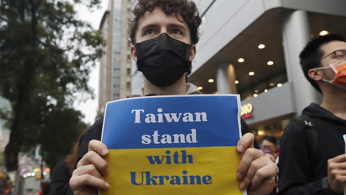台湾举行抗议游行，这名抗议者手举”台湾与乌克兰在一起“的标语牌。