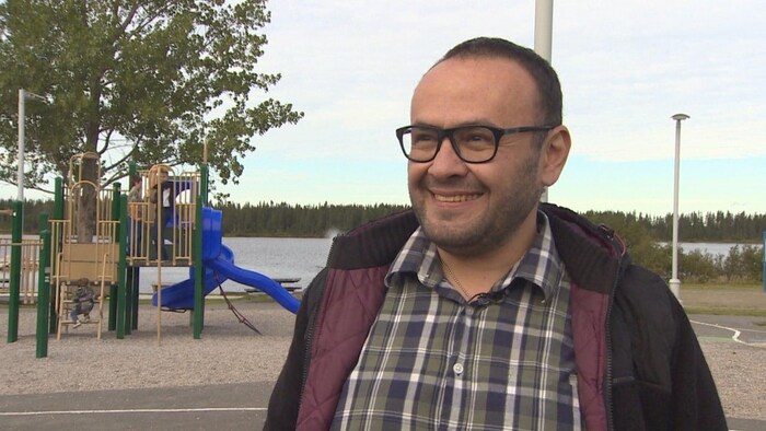 Portrait of Talal Ibrahim in front of playground by the water.