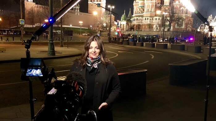 تامارا ألتيريسكو تتحدث أمام الكاميرا في إحدى ساحات موسكو ليلاً.