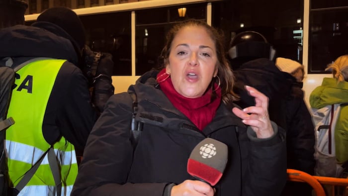 La journaliste Tamara Alteresco, micro à la main, fait un compte rendu d'une manifestation à Moscou.