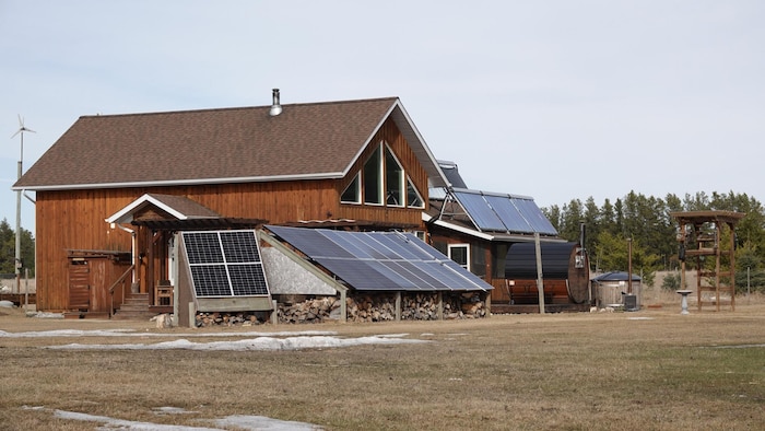 une maison en bois et des panneaux solaires