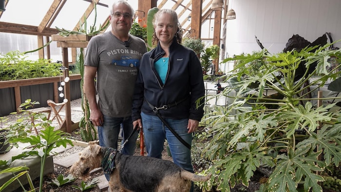 Janice et Daniel Dumont et un chien dans une serre