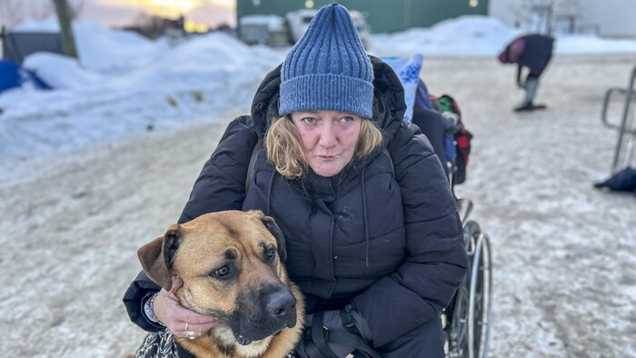 Tammy assise avec son chien Thor au centre d’accueil Energy Court, Sudbury.