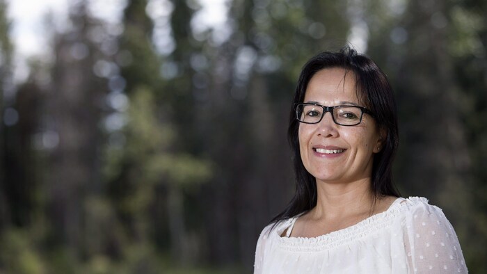 Portait of Tammy Cook-Searson with forest in background.