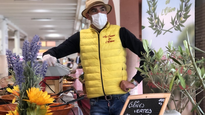 Tao Deliere, derrière son kiosque où il offre différentes variétés d’olives.